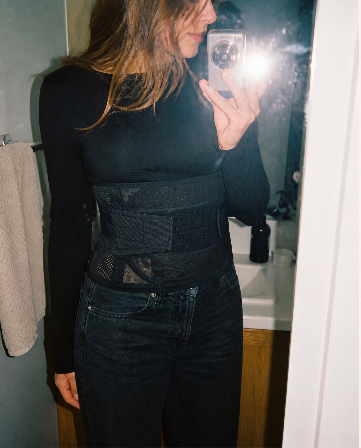 Black and nude Grace Tummy Bands showing the breathable mesh and crossing straps