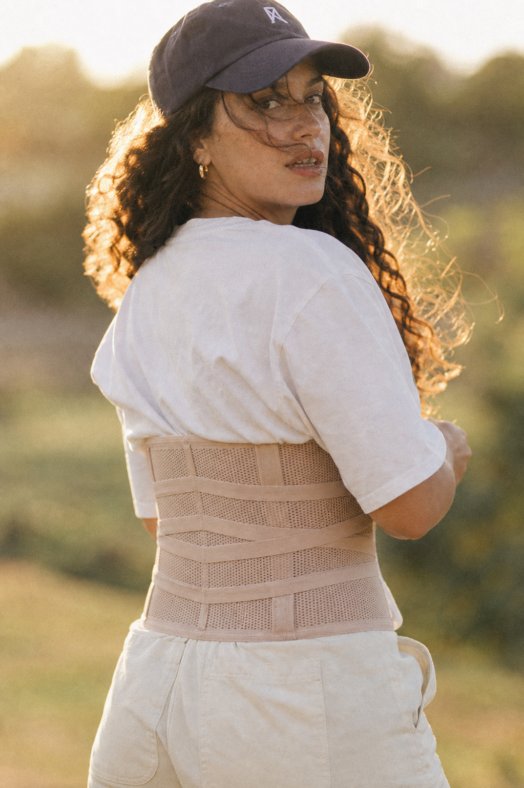 Woman wearing the nude Grace Tummy Band openly in warm evening light